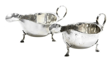 A pair of George V silver sauce boats, with a scroll handle, raised on three hoof feet, Birmingham 1928, 5.85oz.