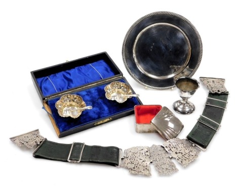 An early 20thC silver plated and green leather nurse's belt, with embossed and pierced floral decoration, together with a pair of silver plated salts with spoons, cased, plated ring box, a dish and an egg cup.