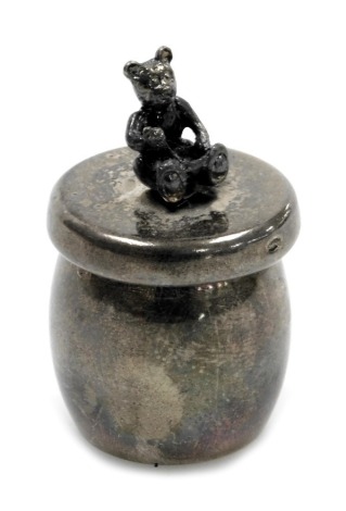 An Elizabeth II silver rouge pot and cover, modelled as a bear, possibly Winnie the Pooh, seated on a honey pot, Sheffield 2002, 0.76oz.