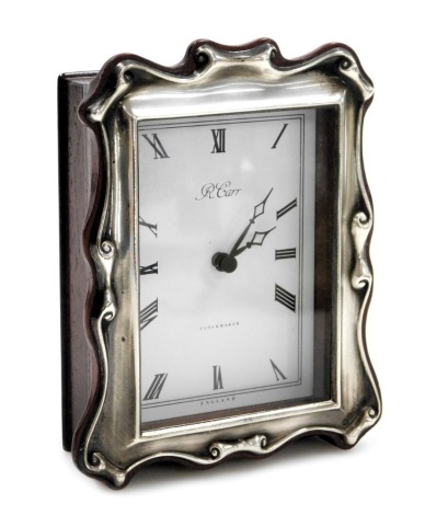 An R Carr silver and mahogany cased strut clock, rectangular dial bearing Roman numerals, battery movement, the back with silver plaque presentation engraved, Sheffield 1991, 13cm high, 10cm wide.