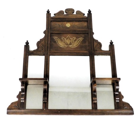 A Victorian mahogany framed overmantel mirror, with a carved pediment above floral panels, rectangular glass plate, flanked by two further glass plates with shelves to the front, 89cm x 68.5cm.