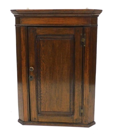 A 19thC oak hanging corner cupboard, with an outswept pediment over a panelled door enclosing two shelves, 88cm high, 66cm wide, 30cm deep.