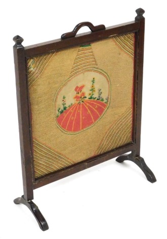 An early 20thC oak fire screen, with a square woolwork tapestry, stitched centrally with a dainty lady, 73cm x 56.5cm.