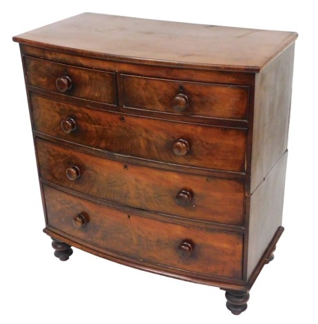 A Victorian mahogany bow front chest, of two short over three long graduated drawers, raised on turned feet, 108cm high, 103cm wide, 55cm deep.