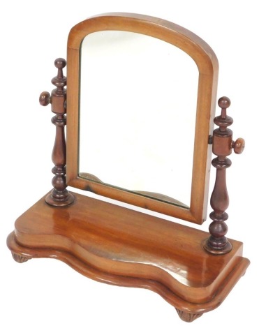 A Victorian mahogany swing frame toilet mirror, raised on a serpentine base, on leaf carved feet, 60cm high, 55cm wide.