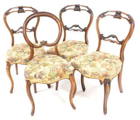 Three Victorian walnut balloon back dining chairs, upholstered in vine pattern fabric, raised on cabriole legs, and a further balloon back dining chair, similarly upholstered. (4)