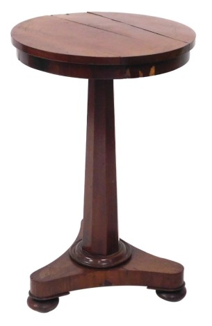 A late Regency mahogany occasional table, the circular top raised on an octagonal column, above a triform base, on bun feet, 70cm high, 43cm wide.