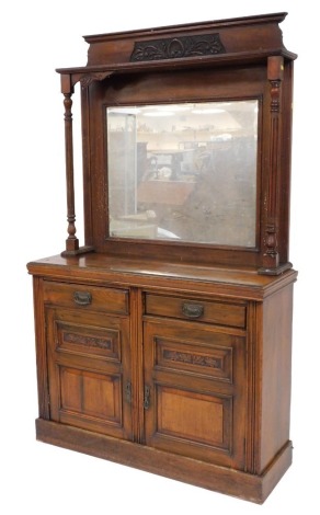 A Victorian walnut mirror backed sideboard, with a shell and foliate carved pediment, over a rectangular bevelled mirror plate, and a super structure with turned and reeded columns, above two short drawers over two carved panelled doors, raised on a plint