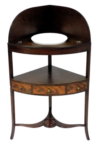 A George III mahogany bow front corner washstand, the galleried top with a recess for a bowl, and two smaller recesses, above a shelf with three frieze drawers, raised on slender out swept legs, united by an under tier, 104cm high, 45cm deep.