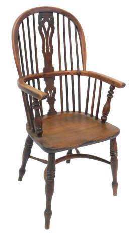 A 19thC yew and elm stick back Windsor chair, with a carved splat, solid saddle seat, raised on turned legs united by a crinoline stretcher, 53cm wide.