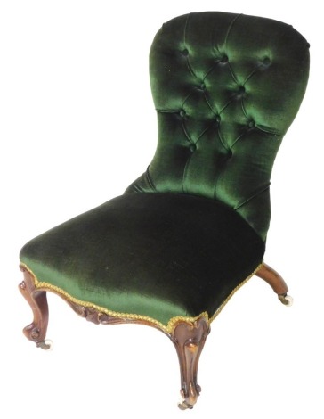 A Victorian mahogany balloon back nursing chair, upholstered in green draylon, raised on cabriole legs, on castors, 50cm wide.