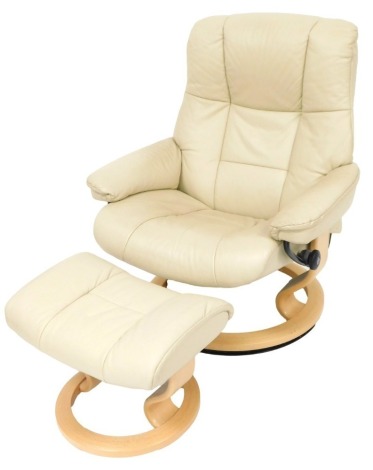 A Stressless type cream leather armchair, 74cm wide, with matching footstool.