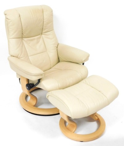 A Stressless type cream leather armchair, 74cm wide, with matching footstool.