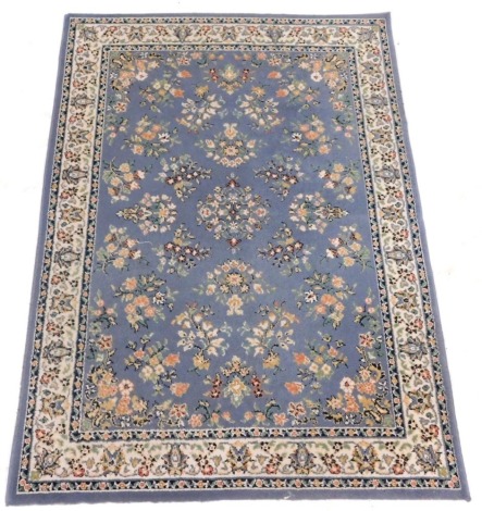 An Afghan blue ground rug, the central field decorated with flowers, within repeating floral borders, 168cm x 120cm.