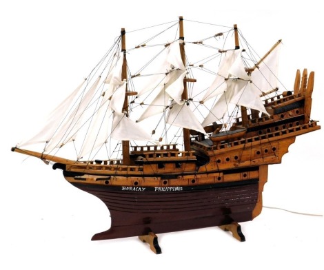 A wooden scale model of a three masted galleon, named for Boracay Philippines, on a wooden cradle, fully rigged with sails, 76cm wide.