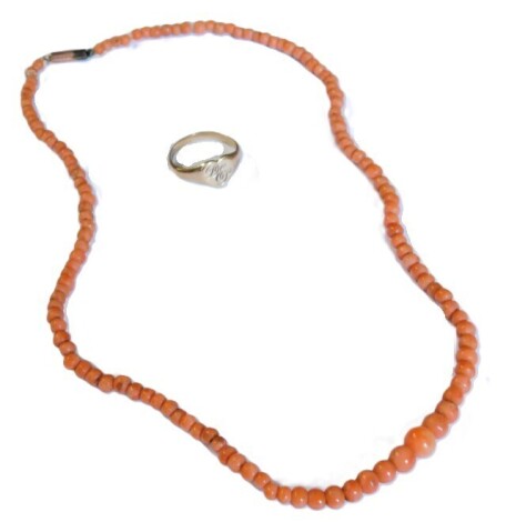 A string of coral beads, on a snap clasp, stamped 9ct, together with a 9ct gold lady's heart shaped signet ring, monogram engraved, size L, 2.1g.