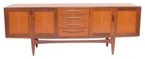 A mid century G-Plan Brasilia teak sideboard, the rectangular top above four central drawers flanked by two pairs of cupboards, on tapering legs united by stretcher, 80cm high, 205cm wide, 45cm deep.