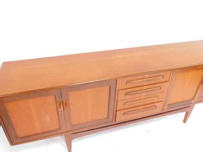 A mid century G-Plan Brasilia teak sideboard, the rectangular top above four central drawers flanked by two pairs of cupboards, on tapering legs united by stretcher, 80cm high, 205cm wide, 45cm deep. - 2