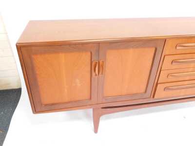 A mid century G-Plan Brasilia teak sideboard, the rectangular top above four central drawers flanked by two pairs of cupboards, on tapering legs united by stretcher, 80cm high, 205cm wide, 45cm deep. - 3