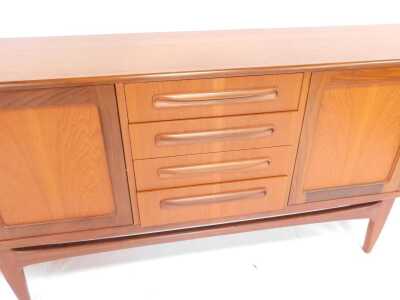 A mid century G-Plan Brasilia teak sideboard, the rectangular top above four central drawers flanked by two pairs of cupboards, on tapering legs united by stretcher, 80cm high, 205cm wide, 45cm deep. - 4