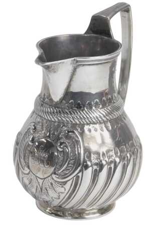 A Victorian silver cream jug, of part fluted design, bearing crest bearing the initials A M, Charles Stuart Harris, London 1885, 11cm high, 5.23oz.