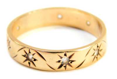 A 9ct gold eternity ring, with eight etched star decorations, each set with a tiny diamond, ring size R½, 3.1g all in.