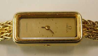 An Omega lady's 18ct gold cased wristwatch, rectangular gilt dial, quartz movement, on a two colour integral mesh strap, with snap clasp, strap numbered 791.9087A, boxed, 28.2g all in. - 2