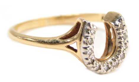 A horseshoe dress ring, the arched horseshoe set with tiny diamonds, on V splayed shoulders, in a raised mount, yellow metal stamped 10kt, ring size O½, 2.2g all in.