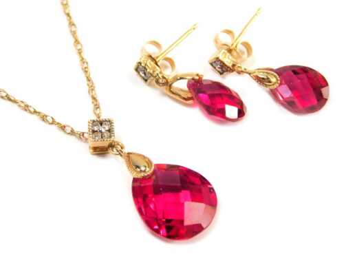 A ruby and diamond set jewellery suite, comprising pendant and earrings, each with a teardrop ruby drop, and tiny diamond set top, yellow metal stamped 14k, the pendant 2cm high, the chain 40cm long, the earrings 1.5cm high, each on single pin with butter