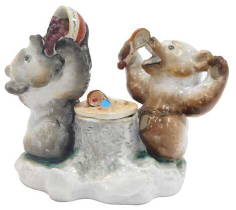 A Lomonosov porcelain inkwell, modelled as two bears, one eating fruit from a bowl, the other holding a spoon beside a tree stump, the lid enclosing a vacant interior, 13cm high.