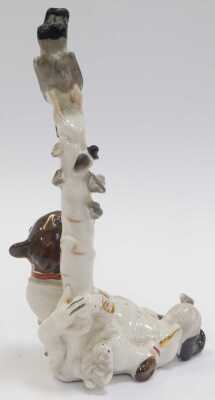 A Russian porcelain figure, modelled as a seated bear in military uniform leaning against tree with bird to top, 22cm high. - 2