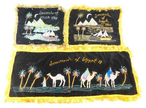 Three Souvenir of Egypt embroidered velvet panels, each dated 1941, two depicting the pyramids from the River Nile, 30cm x 45cm, and the other figures riding and leading camels, 33cm x 86cm, each with fringed borders, by repute prisoner of war pieces.