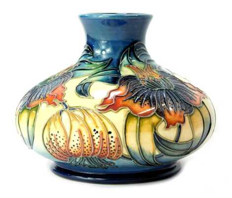 A Moorcroft pottery vase decorated in the Hibiscus pattern, of squat form, impressed marks and dated 98, 11cm high, boxed.