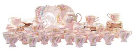 A Tuscan porcelain part tea and coffee service, decorated with flowers against a pink ground, gilt heightened, to include a coffee pot, teacups and saucers, side plates, milk jugs, etc. (1 tray and loose)