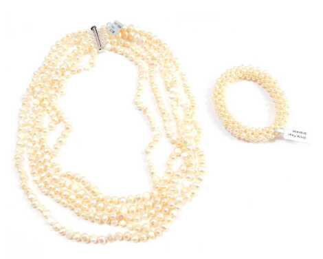 A white cultured pearl five strand graduated necklace, with barrel clasp, white metal stamped 925, 52cm long, and a white cultured pearl bracelet. (2)