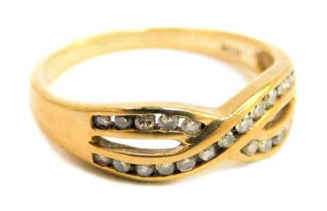 A dress ring, formed with two links crossed over, set with tiny diamonds, in a yellow metal setting stamped 10kt, size O½, 2.5g all in.