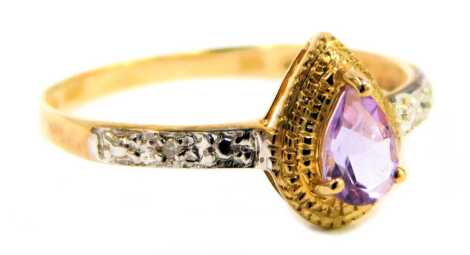 A lady's dress ring, claw set with a central amethyst coloured stone, flanked by small diamonds to each shoulder, marked 375, ring size O, 1.2g all in.