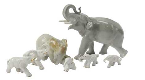 A USSR porcelain elephant, with trunk raised, 20cm high, an elephant calf seated, 9cm high, and further porcelain elephants.