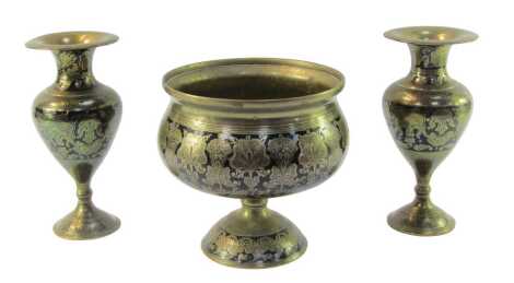 An Indian brass and black enamel pedestal bowl, decorated with foliate motifs, 20cm high, together with a pair of vases, 23cm high.