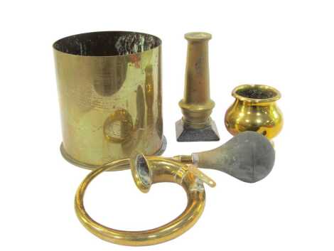 Trench Art. A brass shell case converted to a jardiniere, undecorated, 23cm high, together with a further brass shell case, 14cm high, and a brass section of a table cannon converted to a vase, on a square wooden plinth, 23cm high, and a brass car horn. (