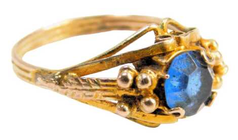 A dress ring, set with a single blue stone in a rub over setting, with ball breaks, on a gold plated band, ring size P½.