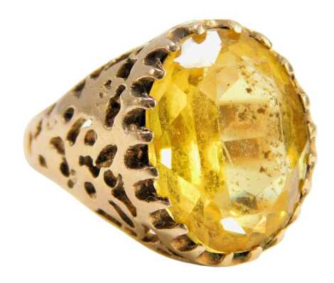 A dress ring, set with a yellow paste stone in a claw setting, with pierced design shoulders and ring mount, yellow metal, stamped 9ct, size O, 6.6g all in.