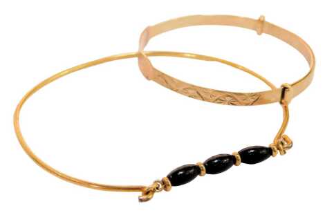 Two bangles, comprising a 9ct gold child's bangle, of expanding form, bearing the name Aiesha, 2.8g, and a further bangle set with three black onyx beads, unmarked. (2)