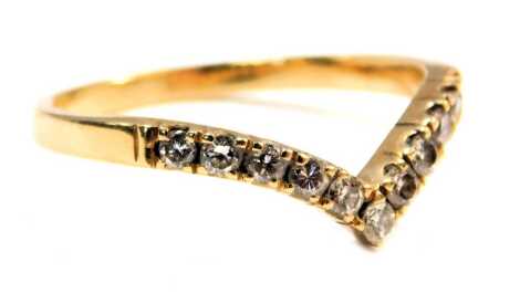 A wishbone ring, set with tiny diamonds, on a yellow metal band, unmarked, ring size M, 2.1g all in.