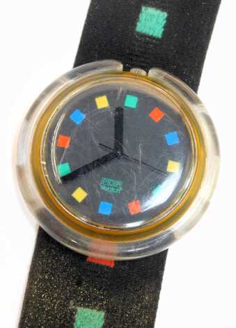 A Swatch Pop watch, with a black dial with red, yellow, green and blue outer batons and matching strap, the dial 3.5cm diameter.