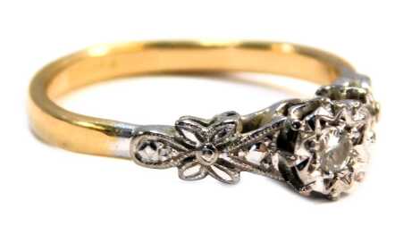 A dress ring, of bicolour design, with raised central tiny diamond, in a star setting, floral design shoulders, on a yellow metal band, stamped plat, ring size M, 2.7g all in.