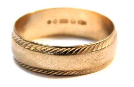 A 9ct gold wedding band, the hatched outer border, on a plain central band, maker LW, London 1983, ring size M½, 2.5g all in.