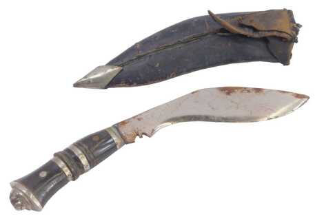 A Middle Eastern kukri sheath knife, with an ebonised and stainless steel handle, curved blade with leather scabbard, 26cm wide.