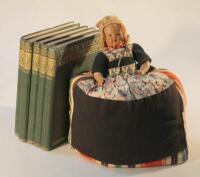 A 20thC tea cosy in the form of a Dutch girl and books