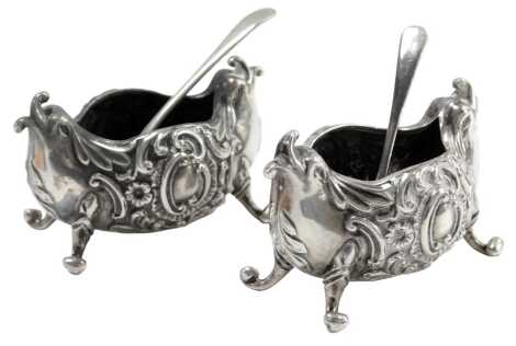 A pair of Victorian silver salts, each of rococo style boat form, Brockwell and Son, Birmingham 1894, 2.42oz, and two silver plated spoons. (4)